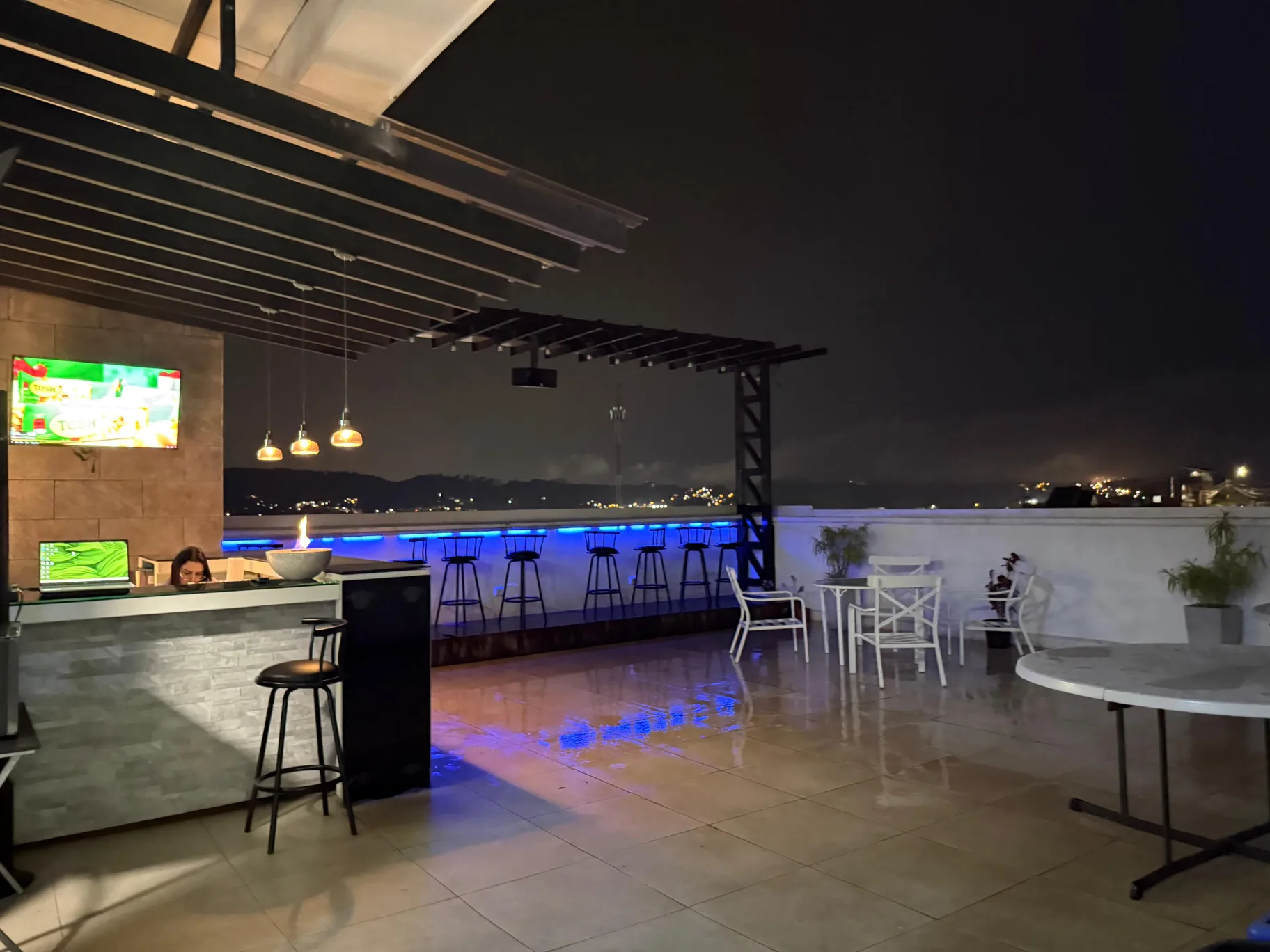 The terrace at Crocode’s offices at dusk, with tables, warm lighting and a view of the city